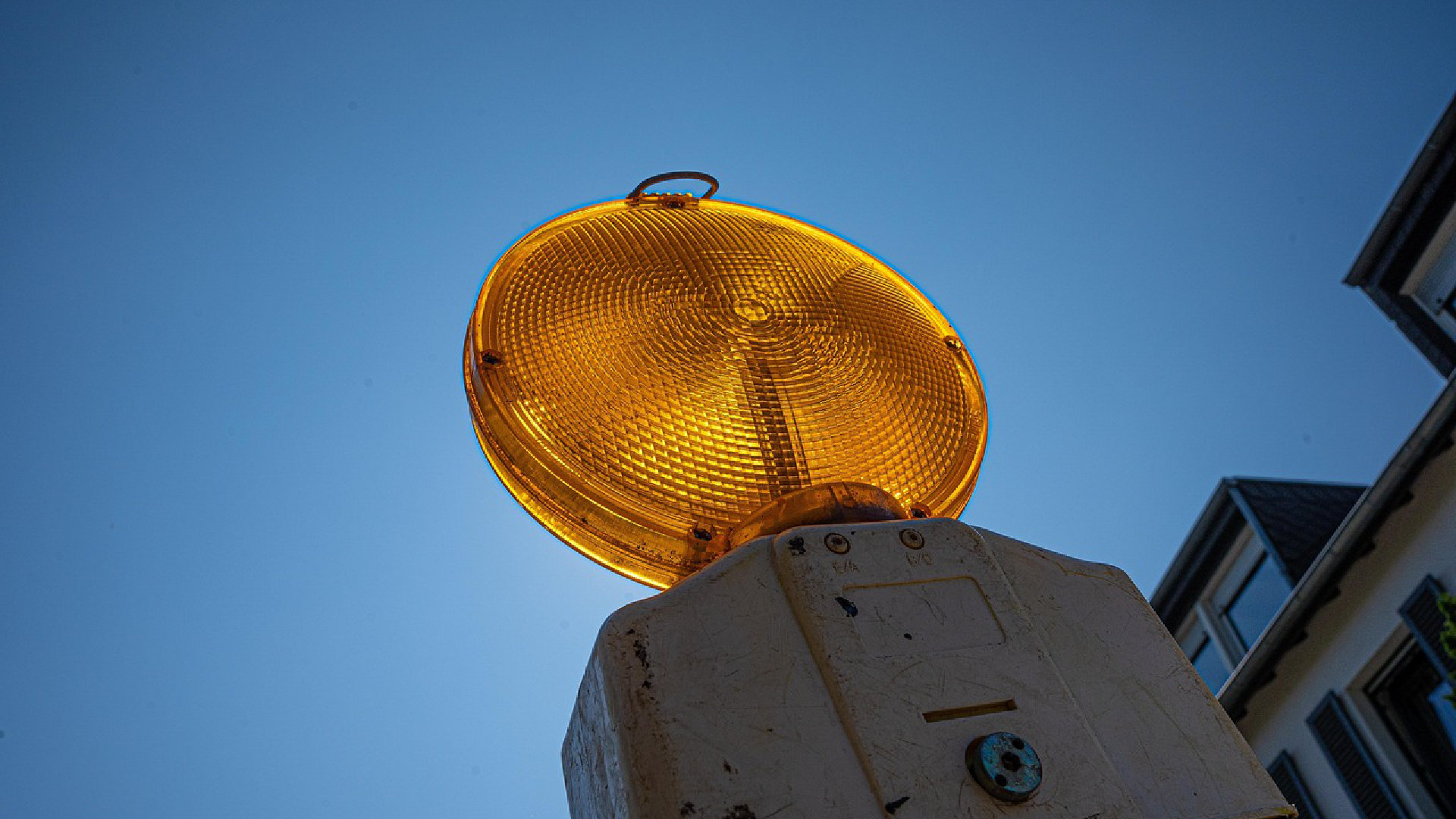 Die Warnlampe einer Baustelle ist vor blauem Himmel zu sehen.