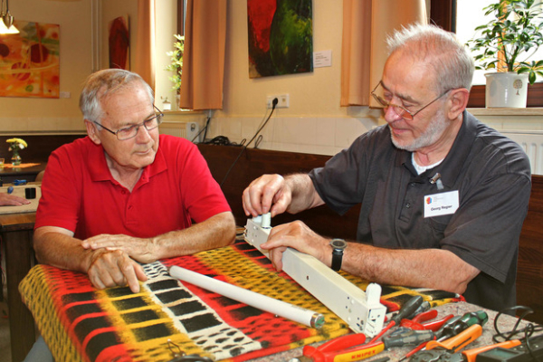Zwei Ehrenamtliche des Reparatur-Cafés Stuhr reparieren eine Lampe