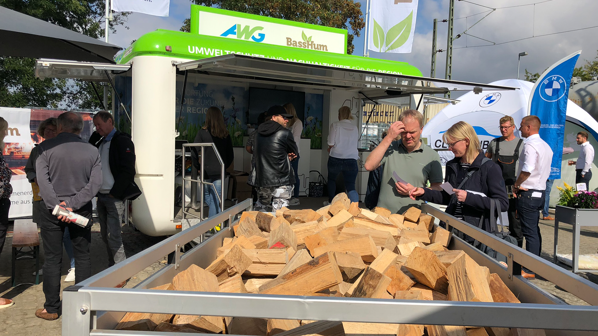 Anhänger mit Holzscheiten und Menschen.