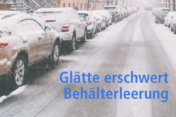 Eine zugeschneite Straße mit beidseitig geparkten Autos.