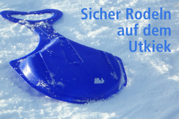 Ein Schlitten liegt auf Schnee.