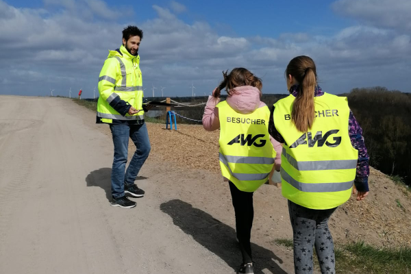 Zwei Mädchen erhalten von einem Mitarbeiter der AWG Informationen zum Bassumer Utkiek. Im Hintergrund ist das Balance-Seil als Sportgerät zu sehen.